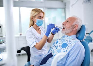 Implant dentist in Granby examining a patient