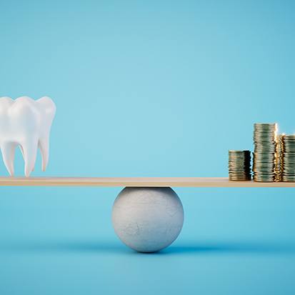 Model tooth and pile of coins on each side of a ball-and-plank scale