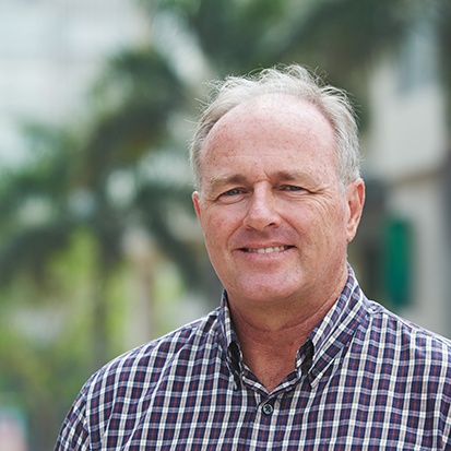 Close-up of senior man in button-up shirt smiling