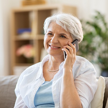 Senior woman sitting on couch talking on phone