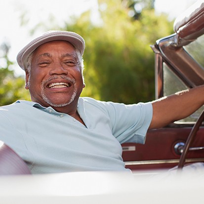 Senior man driving a car and smiling