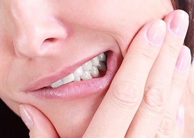 Person in need of tooth extraction holding jaw