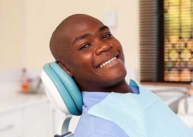 Man dental chair smiling after dental checkup and teeth cleaning
