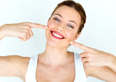 Woman pointing to white teeth