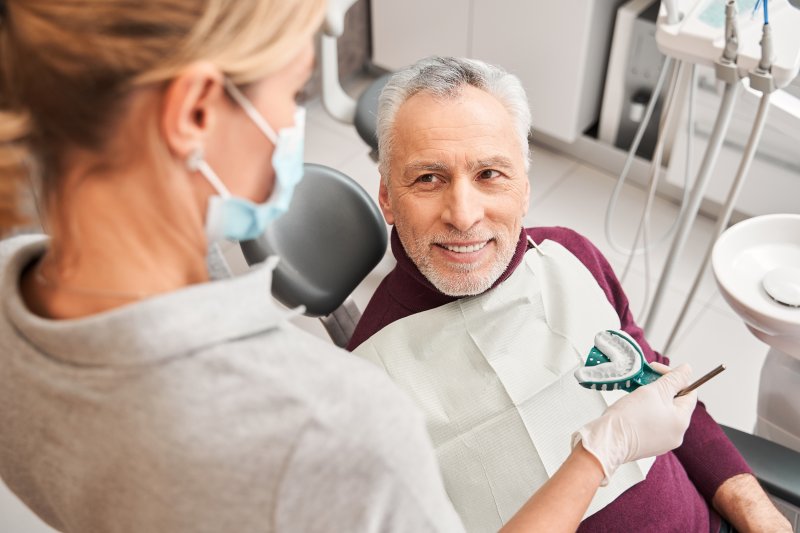 older man wearing dentures at dentist in Granby