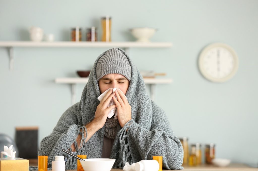 Woman with Invisalign blowing her nose during flu season.