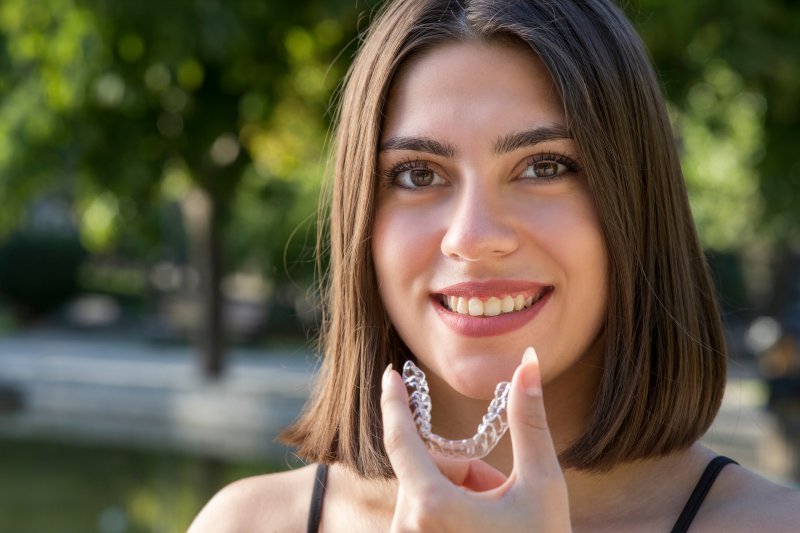 Woman holding Invisalign tray