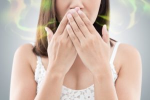 Picture of woman smelling her own breath.